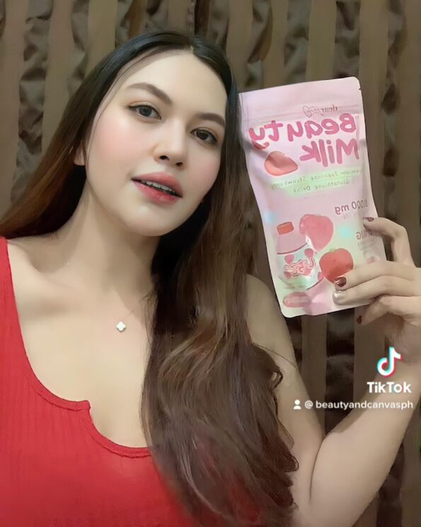 A lady in red shows the product Dear Face Beauty Milk Premium Japanese Strawberry Glutathione Drink (18g x 10 sachets) | Filipino Beauty Products NZ